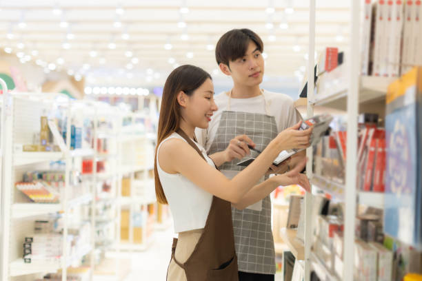 istock Asian people entrepreneur check stock while holding books working at bookstore. 2002642251