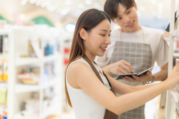 istock Asian people entrepreneur check stock while holding books working at bookstore. 2002642761