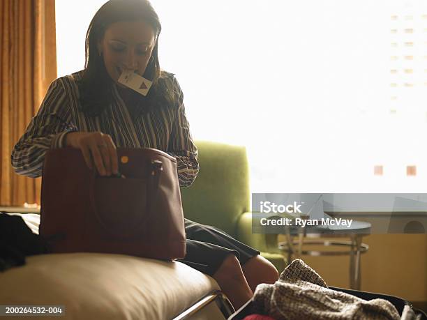 Mature Woman Looking In Purse In Hotel Room Card Key In Mouth Stock Photo - Download Image Now