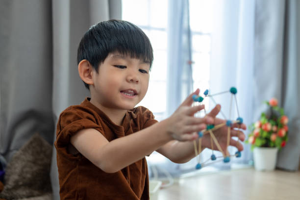istock Asian boy playing with plasticine in the room 2002684817