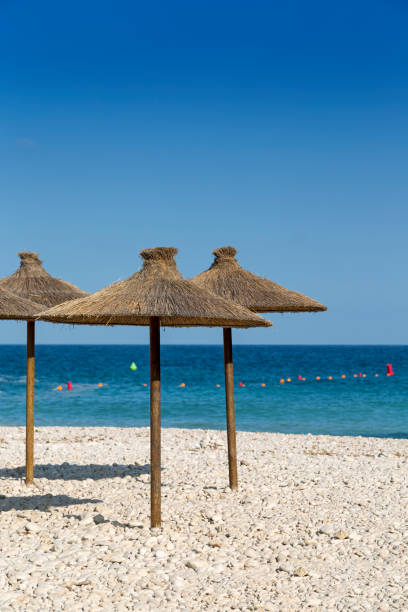 istock Parasols at the beach in front of blue ocean 2002689011
