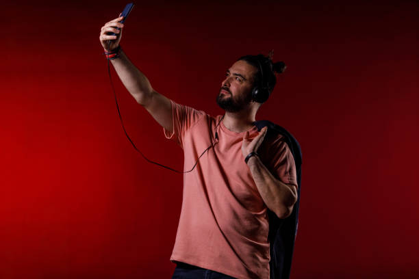 istock Man scrolling through his playlist on smart phone while listening to music 2002700094