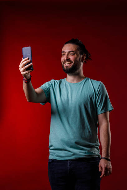 istock Man video chatting with a friend via smart phone 2002704361