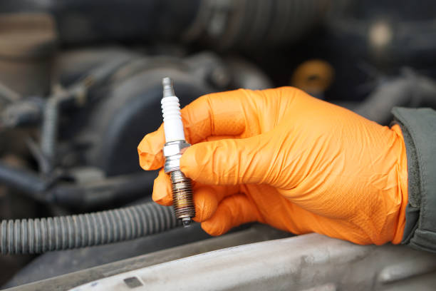 close up mechanic hands hold old spark plug, spare part of car engine. concept, machine maintenance, fix, repair, check or diagnose automobile problems by engine specialist. - spark plug electrode transportation workshop ストックフォトと画像