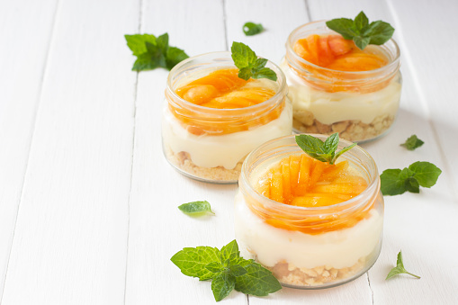 Apricot trifles in glass jar. Sumer dessert background