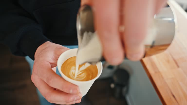 SLO MO Closeup of Male Barista Carefully Pouring Steamed Milk into Coffee Cup and Makes Latte Art in Food Truck