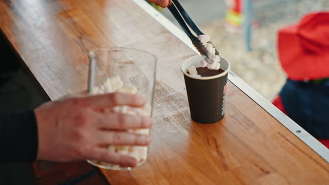 SLO MO Closeup of Food Truck Owner Adding Marshmallows into Paper Cup while Preparing Coffee for Customer