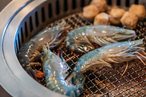 Photo of Grilled river prawns on a hot charcoal grill. Grilled prawns,