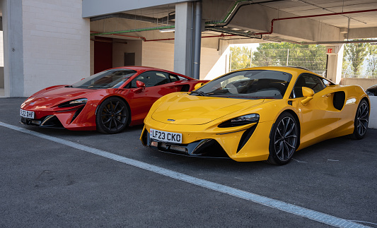 Montmelo, Spain – October 20, 2023: Front view of a pair of modern McLaren Artura supercars, one red and the other yellow