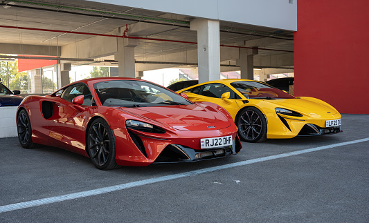 Montmelo, Spain – October 20, 2023: Front view of a pair of modern McLaren Artura supercars, one red and the other yellow