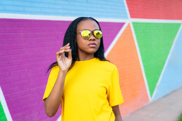 istock Fashionable Young African Lady with Sunglasses Against Triangular Mural 2002827541