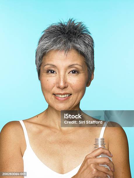 Mature Woman Holding Water Bottle Stock Photo - Download Image Now - One Woman Only, 50-54 Years, Portrait
