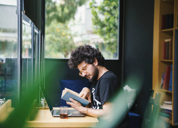 istock Man reading a book during coffee break in his office 2002838751