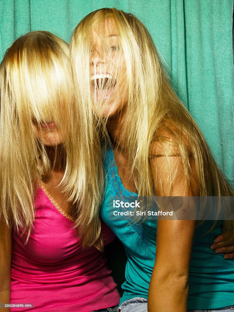 Young women playing around in photo booth  Photo Booth Stock Photo