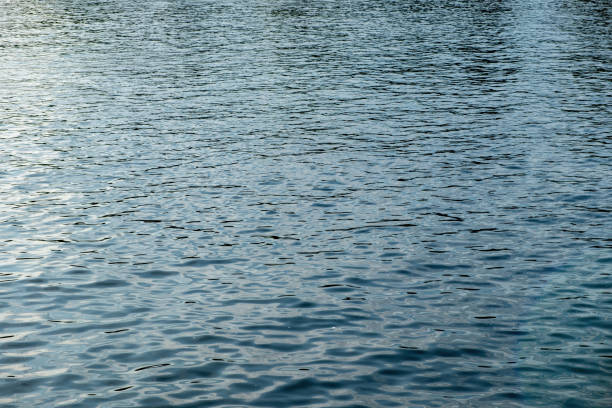 istock Rippled empty sea background texture. Wavy with reflection blue ocean water. Ad template, copy space 2002849686