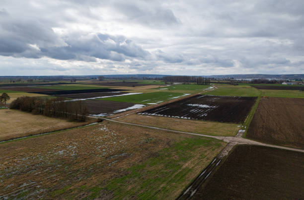 istock Fields in winter with puddles, mud and taunus in the heavily cloudy background 2002853395