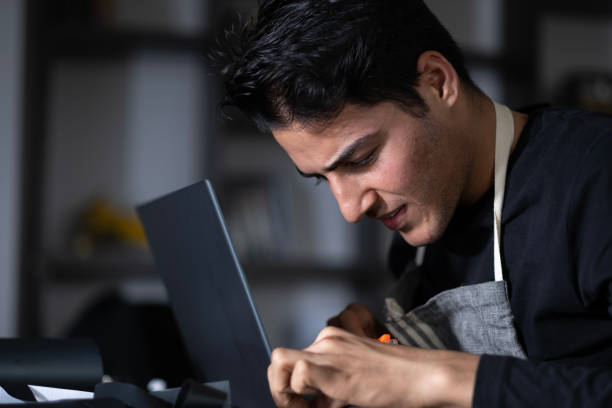 jeune homme réparant son ordinateur portable - technician computer part it support work tool photos et images de collection