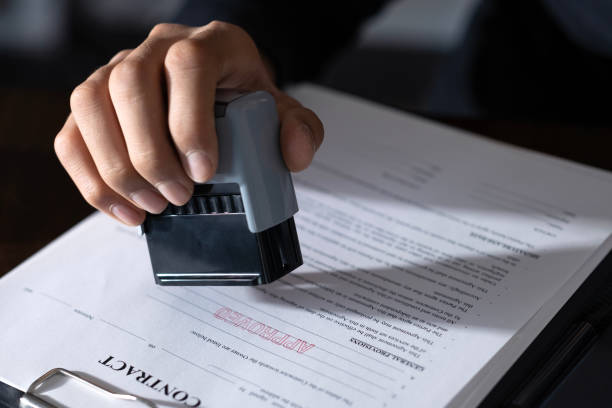 istock Hands of young man approving contract documents with rubber stamp 2002856078