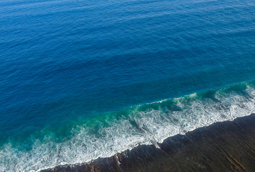 Aerial View of a Serene Blue Ocean with Gentle Waves Approaching Shore