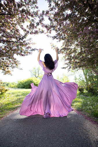 Fairy shoot of a young woman wearing a purple silk dress.