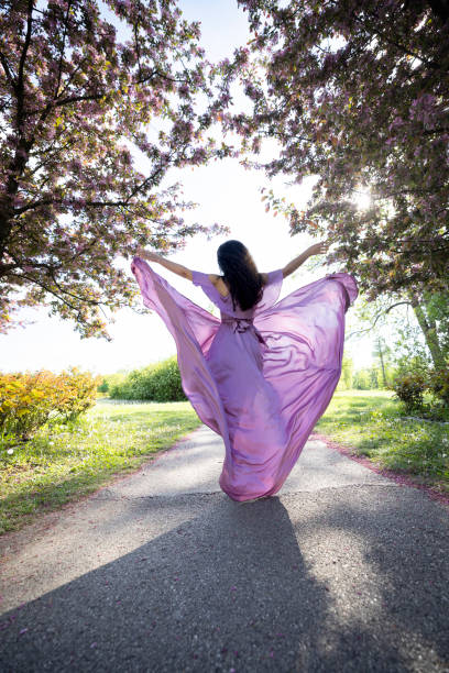 Fairy shoot of a young woman wearing a purple silk dress.