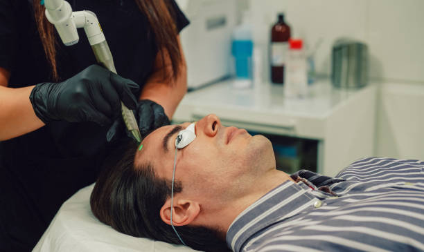istock Man undergoing light peel treatment in beauty clinic 2002923988
