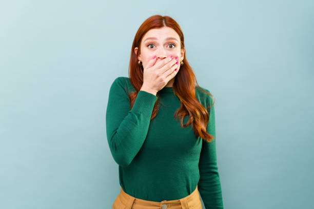 Shocked redhead woman scared and surprised