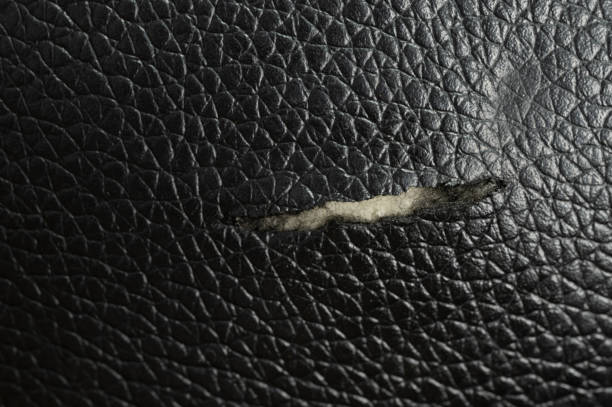 Hole in damaged leather cover macro close up view