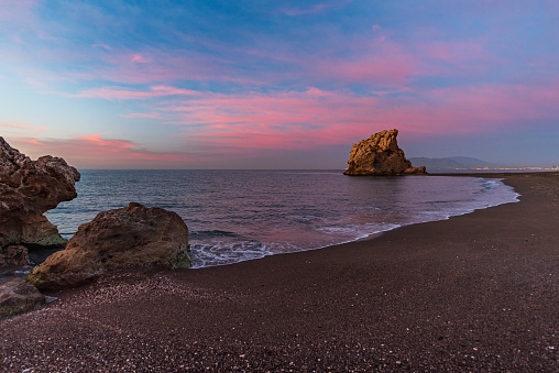 Playa Peñon del Cuervo, beach in the city of Malaga with a rock formation that divides the beach in two, located in the eastern part of the city