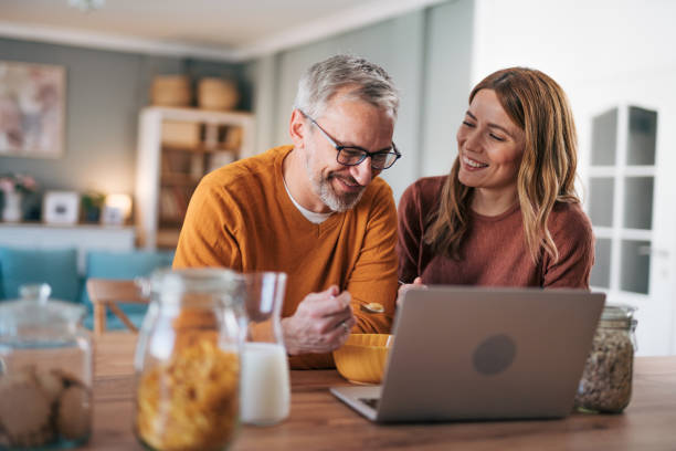 istock mature couple having breakfast together and using their laptop 2003005196