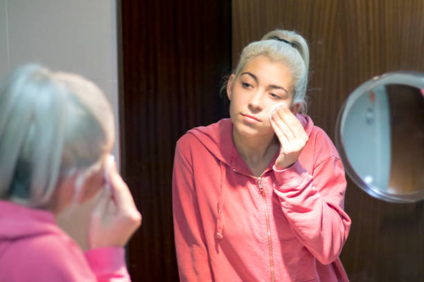 istock Blonde beautiful woman doing makeup in front of mirror 2003005745