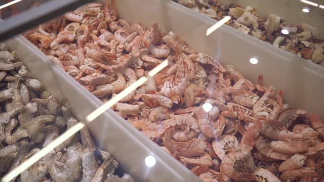 Frozen seafood. Frozen shrimp in a store refrigerator