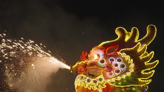 lighted chinese dragon dance in night time ,chiness lantern decorated.happy chinese day festival.For lucky and happiness of chinese people.fring from dragon mouth.