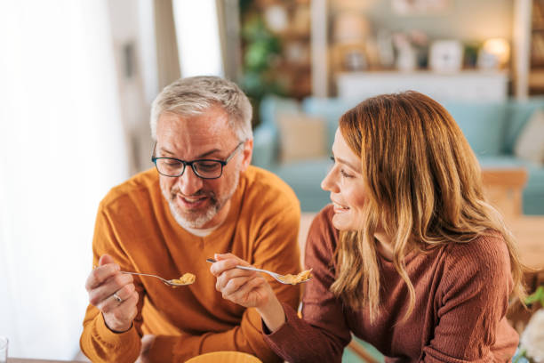 istock Mature happy couple having breakfast together at home and talking. 2003035456