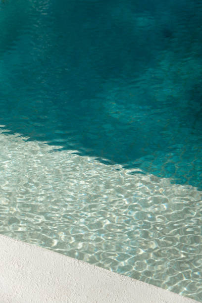 istock Swimming Pool edge with turquoise tiles and sunlight on water surface 2003070574