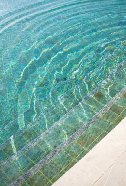 istock Swimming Pool edge with turquoise tiles and sunlight on water surface 2003085278