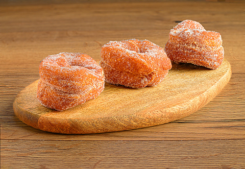 Assorted sugary doughnuts on rustic wooden background