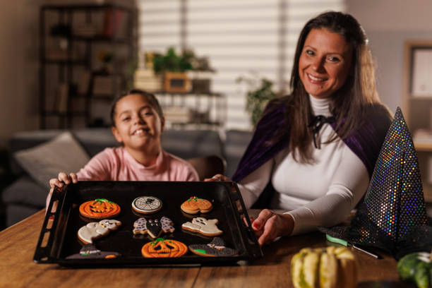 istock Mother and daughter decorating Halloween themed cookies 2003098507