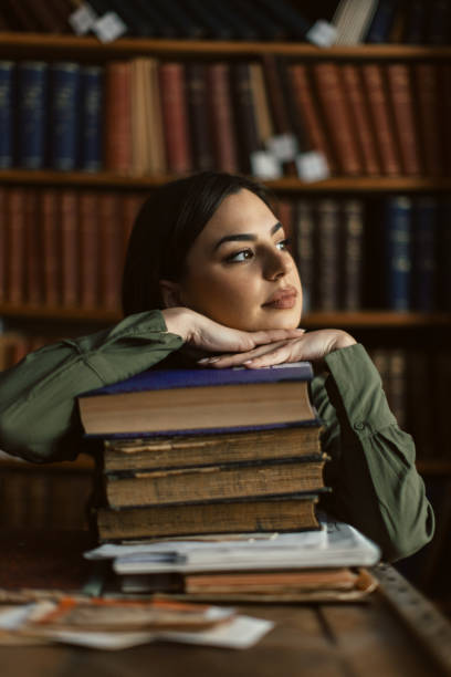 istock Beautiful young woman working in library 2003099050