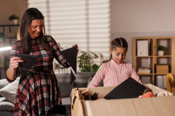 istock Mother and daughter unpacking a box with Halloween decorations 2003099794
