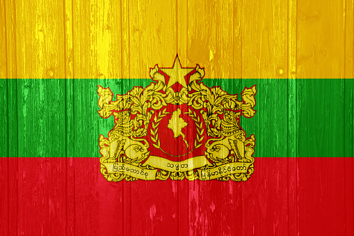 Flag and coat of arms of Republic of the Union of Myanmar on a textured background. Concept collage.
