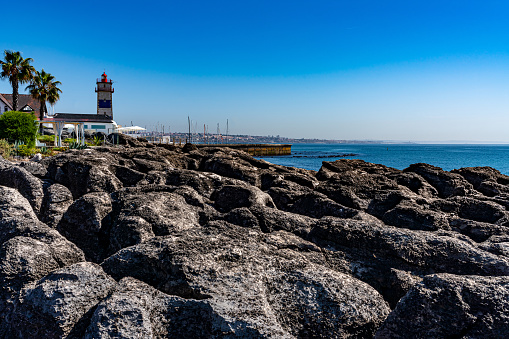 A lighthouse guides to a safe harbor in this inlet harbor marina