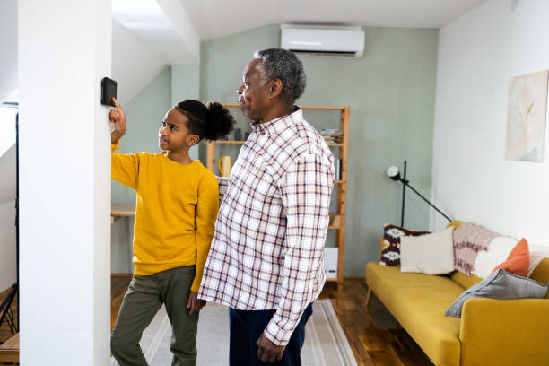 istock Boy and his grandpa turning on home security system 2003166170