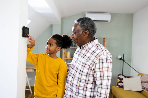 istock Boy showing to his grandpa how to adjust smart home system 2003166173