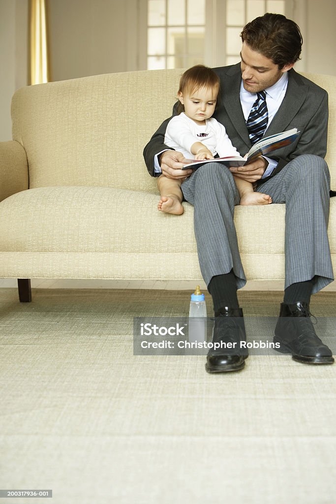 Ojciec z córka czytanie (15-18 Miesiące) na kanapie - Zbiór zdjęć royalty-free (Czytać)