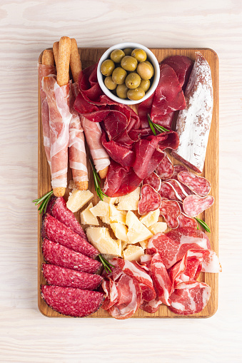 Charcuterie board. Antipasti appetizers of meat and cheese platter with salami, prosciutto crudo or jamon and olives