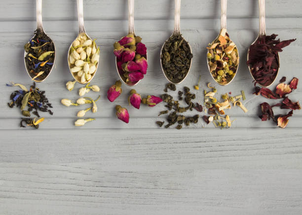 istock Different dried tea in the silver spoons on the gray wooden  background. Top view. Copy space. 2003185355