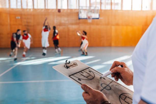 istock Close up of senior coach's hands writing game plan on basketball training. 2003237788