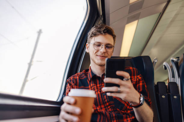 istock A man is traveling by train and typing messages on the phone. 2003238000