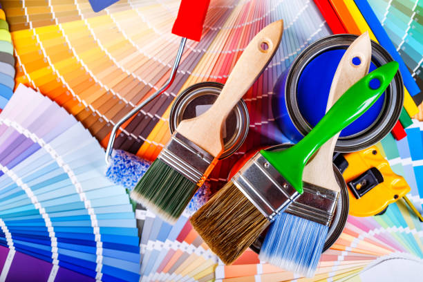 istock Painter and decorator work table with house project, color swatches, painting roller and paint brushes 2003244917